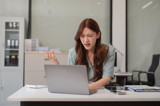 Stress businesswoman is sitting at table, under stress from working.
