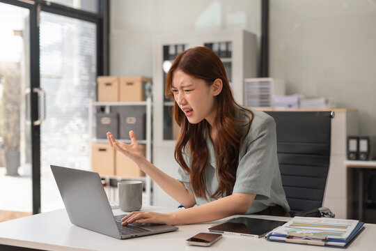 Stress businesswoman is sitting at table, under stress from working. - Powered by Adobe