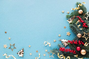 Festive Christmas background or greeting card with green pine branches, red berries and shiny...