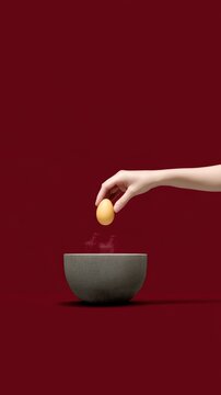A hand cracking an egg into a very hot wok for a kid-friendly fried rice, on a solid deep red background, dramatic wok hei steam and light, fiery wok and yellow egg contrast, dynamic cooking action,