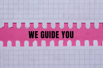We Guide You message written on ripped torn paper background. Conceptual We Guide You symbol. Copy...