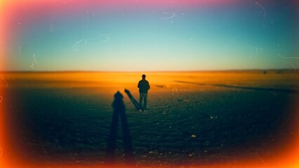Lone figure contemplates the expansive, desolate horizon under a dramatic, vintage twilight sky, evoking solitude
