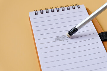 Eraser with traces of dust and graphite and a pencil on book.