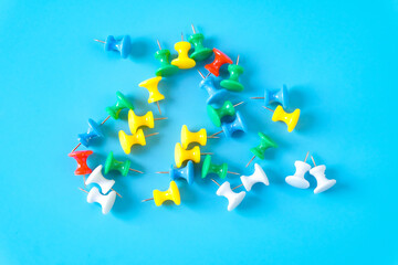 set of colorful push pins on color background.