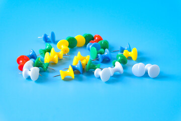 set of colorful push pins on color background.