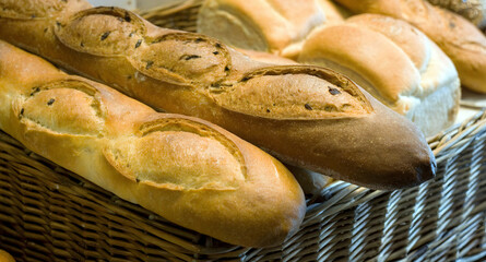 Fresh baked baguettes and loafs in a rustic wicker basket a delicious picnic or family dinner