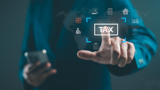 A person in a suit interacts with a digital interface displaying tax-related icons and a world map backdrop.