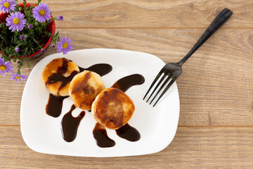Curd fritters with chocolate on the porcelain plate.