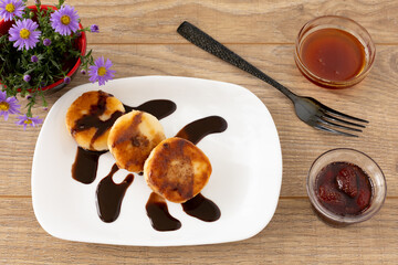 Curd fritters with chocolate, strawberry jam and honey.