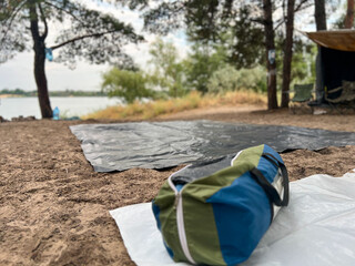 Traveling duffel bag at lake campsite with tarp