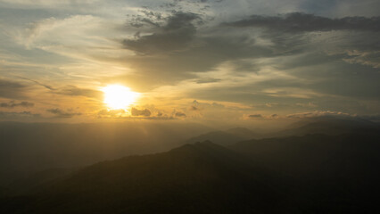 Spectacular evening sunset showcasing descending sun and mountain vistas at Doi Luang Tak in Tak Province, Thailand. 