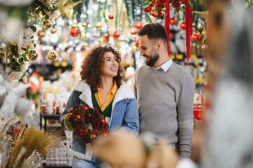 Smiling couple shopping for christmas wreath decorations