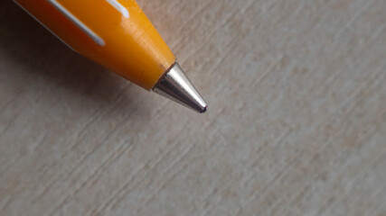 Close-up view of an orange ballpoint pen tip