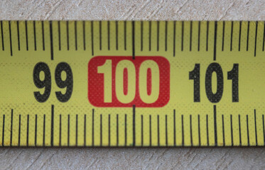 A close-up of a yellow measuring tape at the 100 cm mark