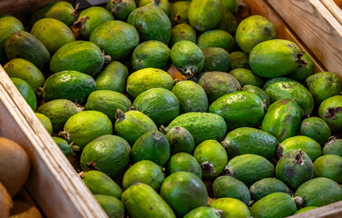 Fresh organic ripe feijoa fruit. Farmers' market with fresh fruits and vegetables. Colorful display of seasonal produce for retail sale. Fruits and vegetables at the market.