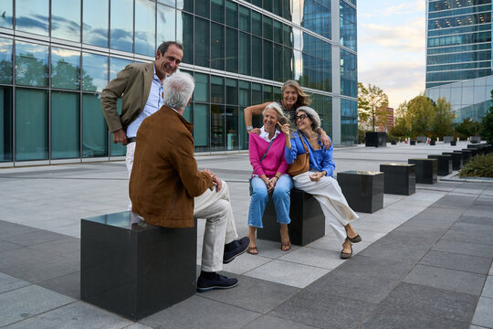 Senior friends enjoying urban social gathering outdoors