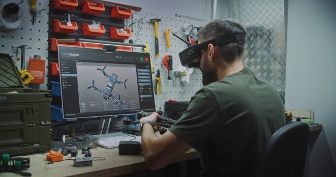 Man Designing and Assembling Drones. Engineer Wearing FPV Goggles Simultaneously Designing Drone on Screen and Assembling Workbench. Concept of Advanced Research and Development in Drone Technology.