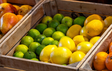 Ripe natural lemons at the market. Farmers' market with fresh fruits and vegetables. Colorful display of seasonal produce for retail sale. Fruits and vegetables at the market.