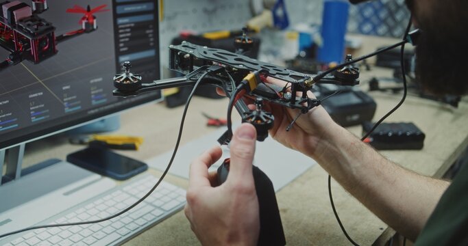 Hands Working on Internal Electronics Drone. Persons Hands Carefully Integrating Internal Electronics and Connecting Antennae on FPV Drone Frame. Concept Precision Assembly and Component Integration.