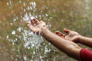 hands with splashes of falling rain