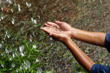hands with splashes of falling rain