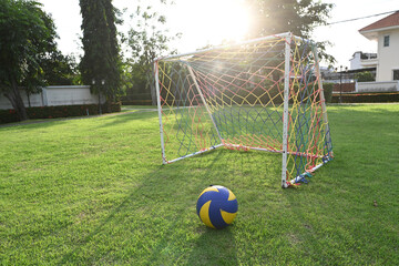  A soccer ball on fresh green grass in front of a soccer goal