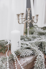 close - up of christmas tree with white snowflakes on the background of the fir - tree branches. candle with number 1