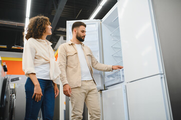 Couple choosing refrigerator in home appliance store