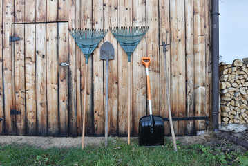 Garden tools leaning against a rustic wooden shed