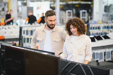 Obraz premium Couple choosing television in electronics store