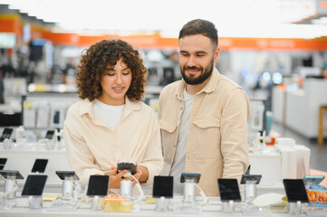 Couple choosing new smartphone in electronics store