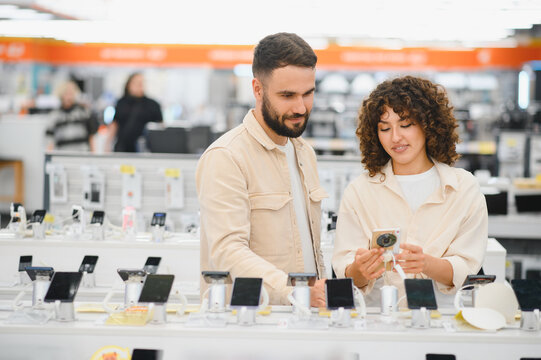 Couple choosing smartphone in electronics store