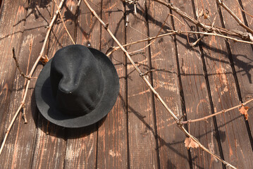 Black hat hanging on a rustic wooden wall