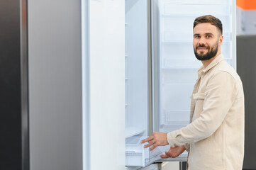 Customer choosing new refrigerator in electronics store