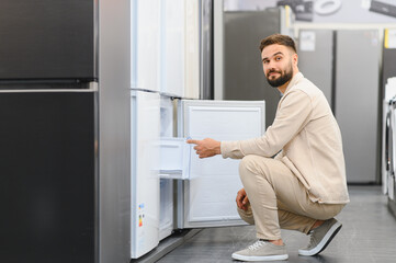 Fototapeta premium Customer choosing new refrigerator in electronics store