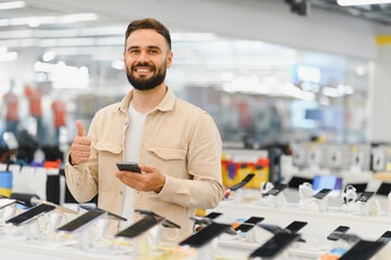 Customer showing thumbs up while choosing smartphone in electronics store