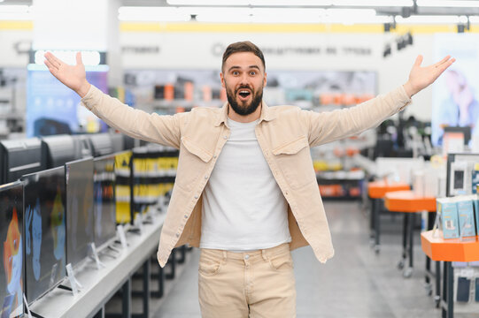 Excited customer showing new appliances in electronics store
