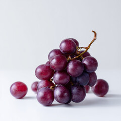 AI-generated image - A fresh bunch of ripe, red grapes with several loose berries, isolated on a clean white background.
