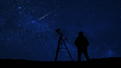 Amateur astro-photographer with a camera on a tripod photographing night sky with stars, planets, Moon and other celestial objects. © astrosystem