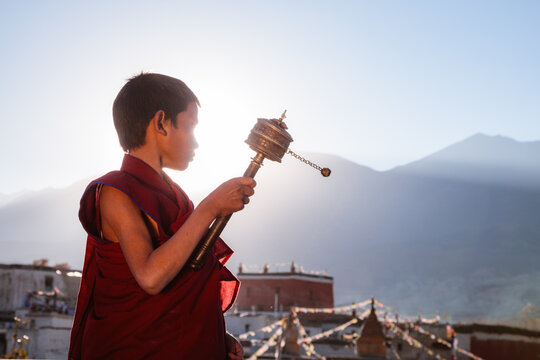Novice monk spinning prayer wheel, Upper Mustang, Nepal
