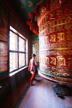 Woman walking around prayer wheel, Kathmandu, Nepal