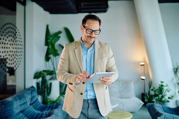 Businessman in smart casual wear interacting with digital tablet in a contemporary office setting, focused on work