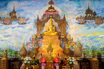 A golden Buddha statue seated on a crystal base with a vibrant celestial mural background.