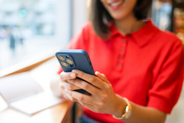 Woman connecting with smartphone, enjoying social media content in cafe