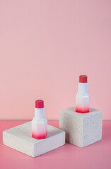 Mockup of black blank thin tube - mascara, lip gloss, gel, eyeliner, oil, etc. Cosmetic package with stylish props on pink background.