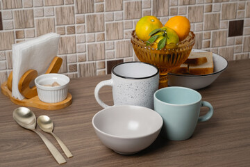 Beautifully arranged breakfast items on a wooden table with fruit and tableware at a cozy kitchen