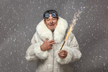 A mature man in a white fur coat with a hood smiles, holding a sparkling sparkler in his hands against a background of swirling snowflakes.