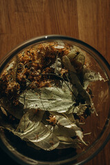 Linden leaves in a closed glass jar close up. Vertical photo. Glass transparent jar with linden - herbal tea eco collection