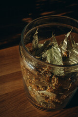 Linden leaves in a closed glass jar close up. Vertical photo. Glass transparent jar with linden - herbal tea eco collection