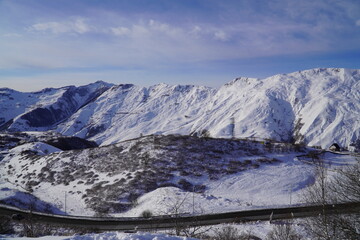 A snow-covered mountain range in the Caucasus region near the Gudauri ski resort. Georgia. Snow-capped mountain peaks and steep slopes.